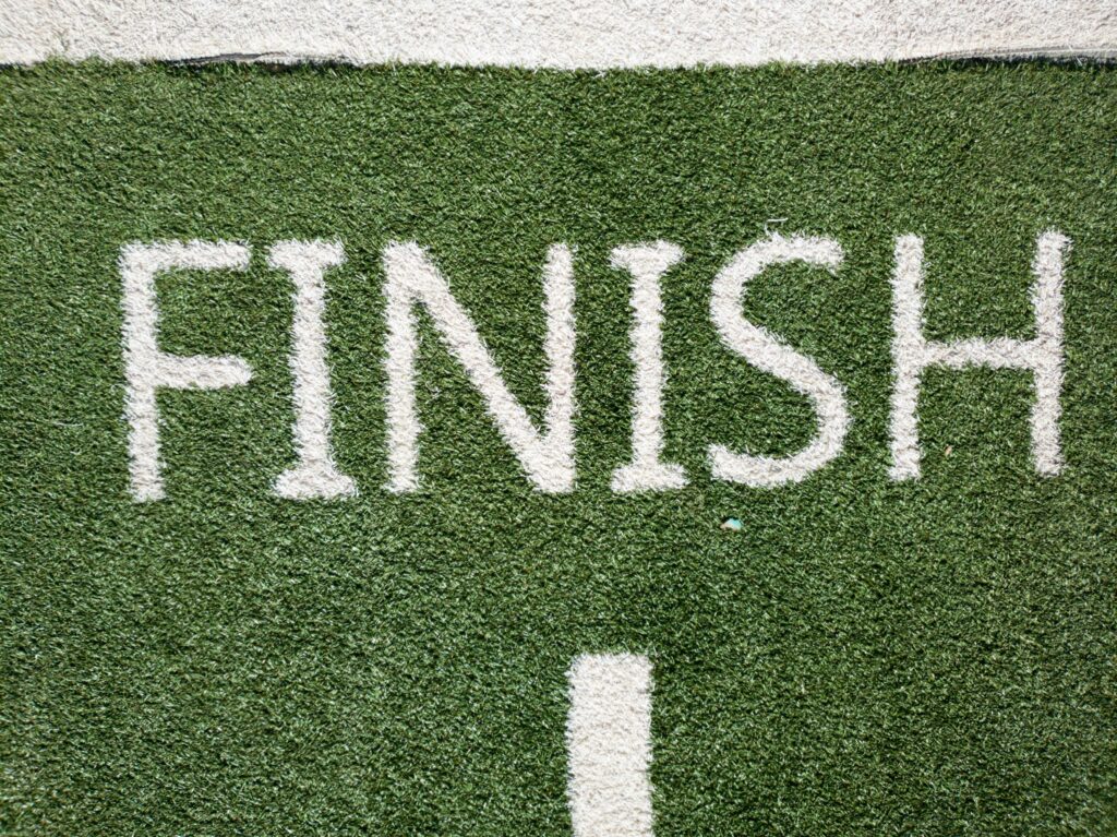 Word 'finish' spray painted white on grass